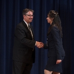 Doctor Smart shaking hands with an award recipeint in a black blazer and skirt